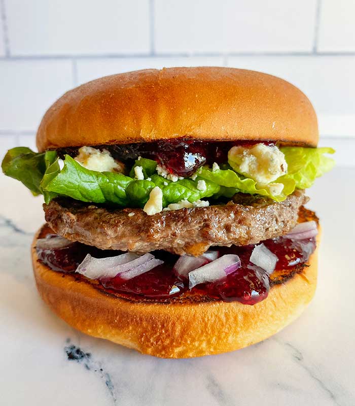 Burger with sauce, lettuce, red onions and cheese from Fanci Freeze in Boise and Meridian Idaho.